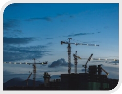 Building Construction Site With Cranes in front of blue sky at night