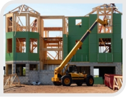 Residential Building Construction Site with Green House and Wood Framing and Yellow Truck